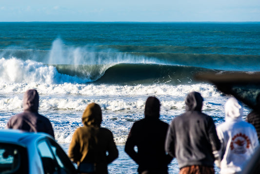 Local surfers watching big waves at Pines surfbreak, Wainui Beach in Gisborne