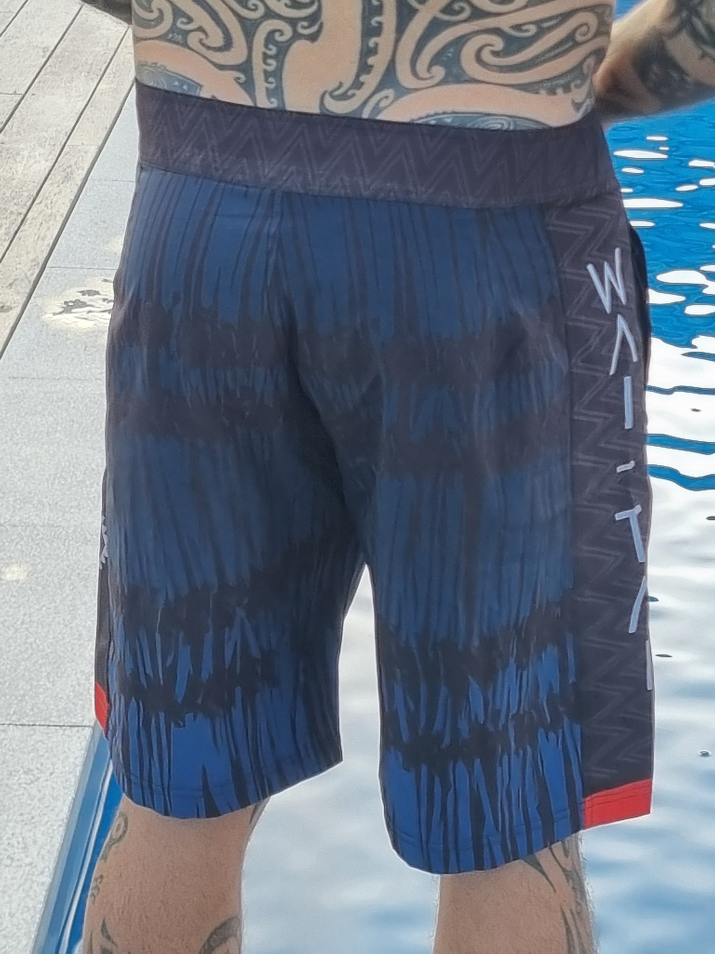 Wai-Tai Aotearoa Piu 4 Way Stretch Maori Boardshorts on Maia Gibbs from the rear