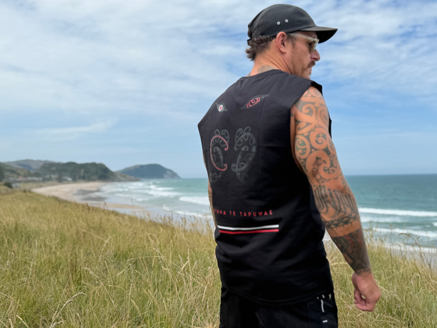 Wai-Tai Tipua Blackout Heavyweight Muscle from back on Maia Gibbs side angle at beach