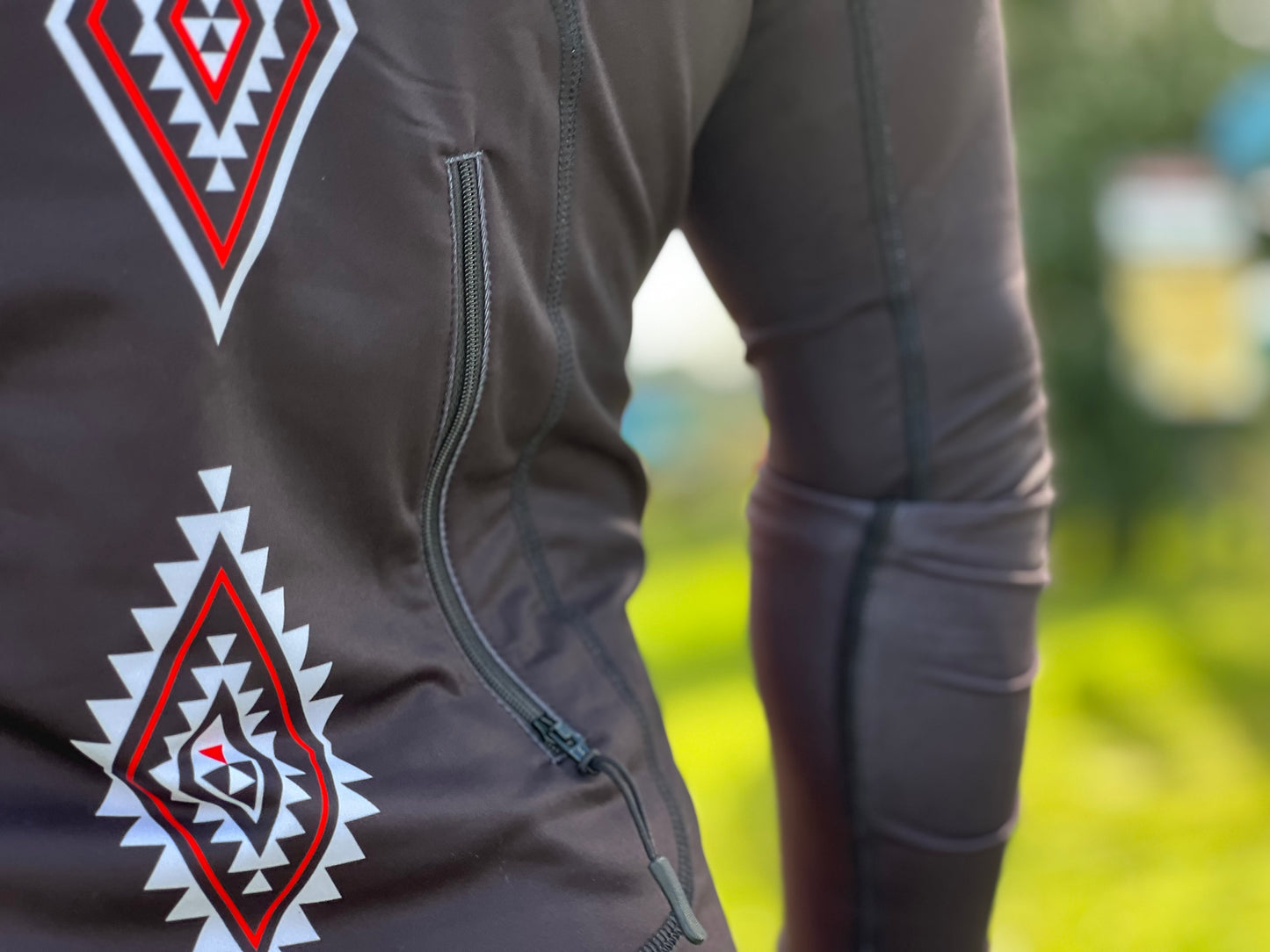 Wai-Tai Aotearoa Patiki Thermal Longsleeve Rash Top on Maia Gibbs holding a waka paddle from rear view showing kidney pocket