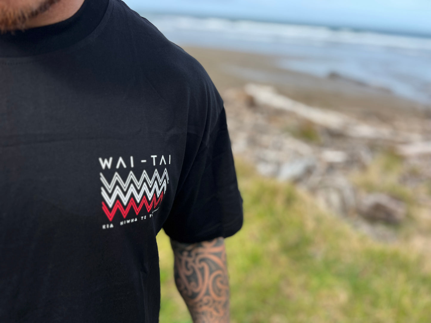 Waitai Aotearoa Kaitiaki Tee front tohu design in white and red close up