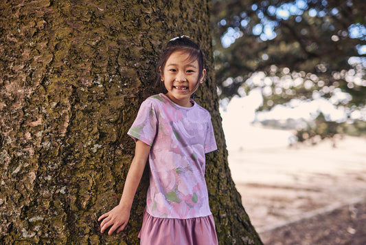 Kissed By Radicool Abstract Floral Tee on model outdoors by tree