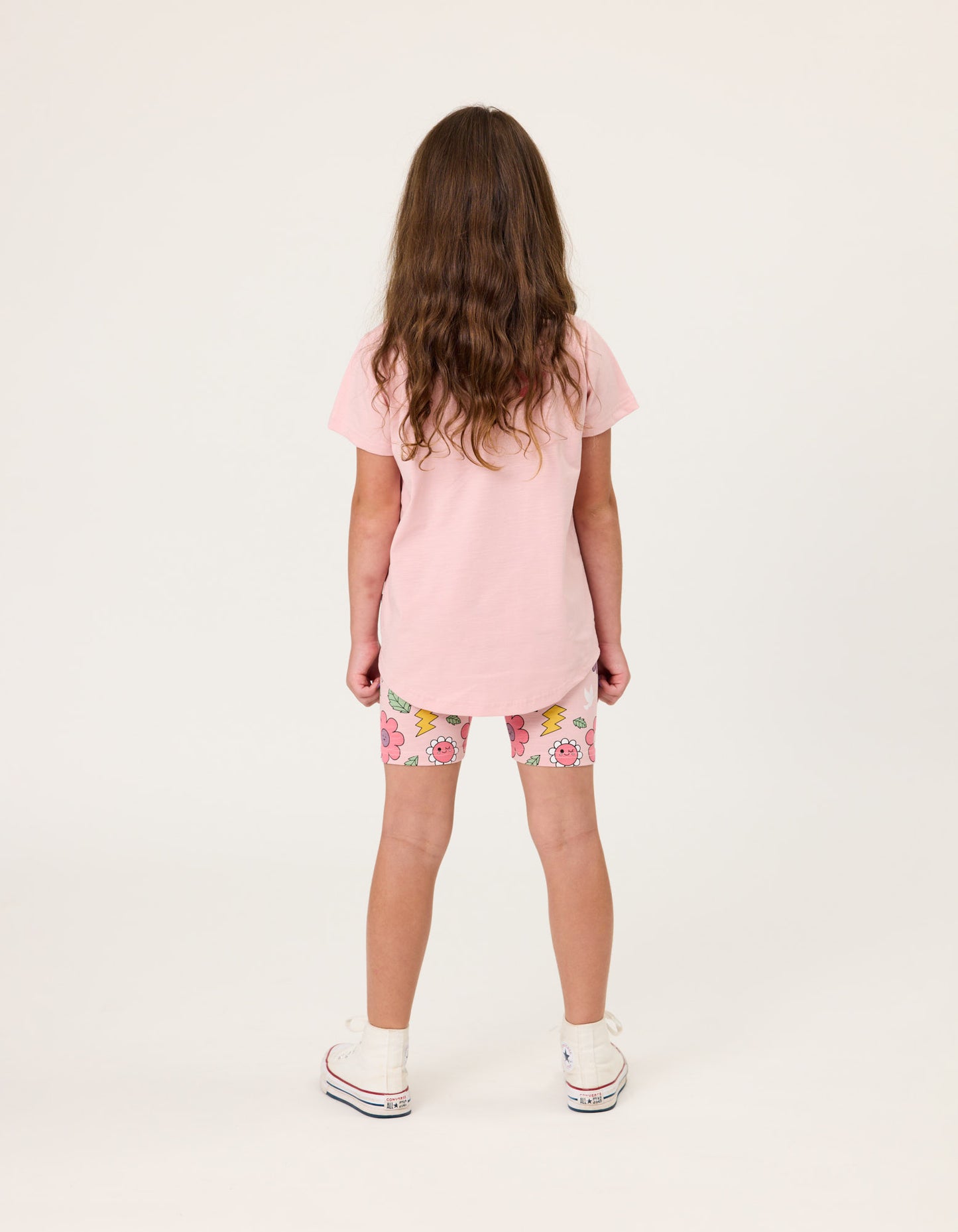 Kissed By Radicool Smiley Flowers Bike Shorts on dark-haired model wearing pink tee from rear