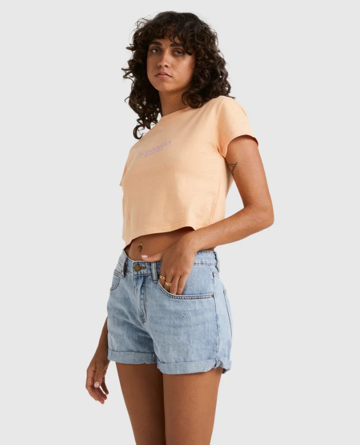 Billabong Frankie 2" Women's Denim Shorts in water blue colourway on model wearing apricot colour tee from side