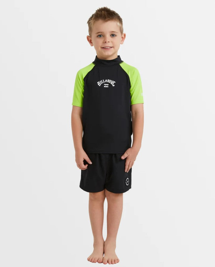 Billabong Groms All Day Arch Short Sleeve Rash Top in black with neon yellow arms on a kids in black shorts