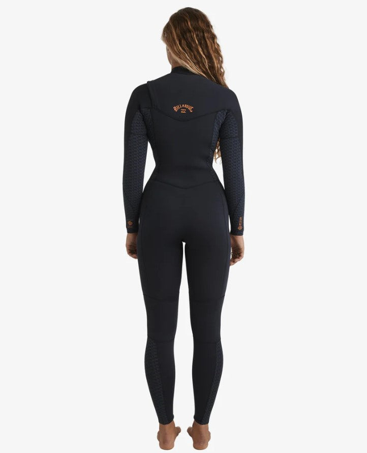 Billabong Synergy Natural 3/2mm Chest Zip GBS Womens Wetsuit in black with geometric patterns on model from rear