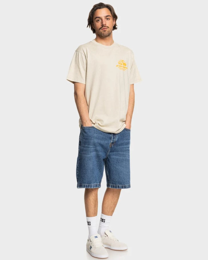 DC Shoes Worker Baggy Denim Shorts in stone indigo colourwya on a man in a beige t-shirt