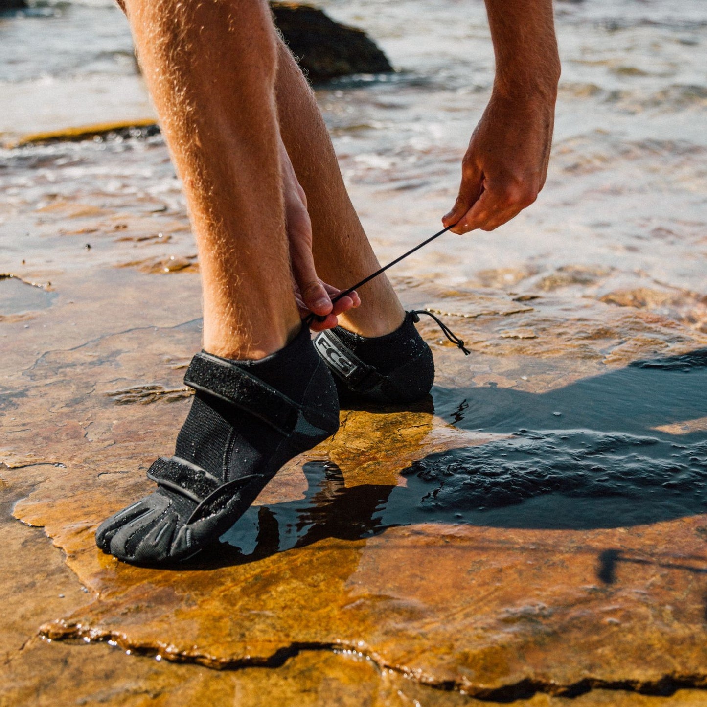 FCS SP2 Reef Boots on person's feet in water