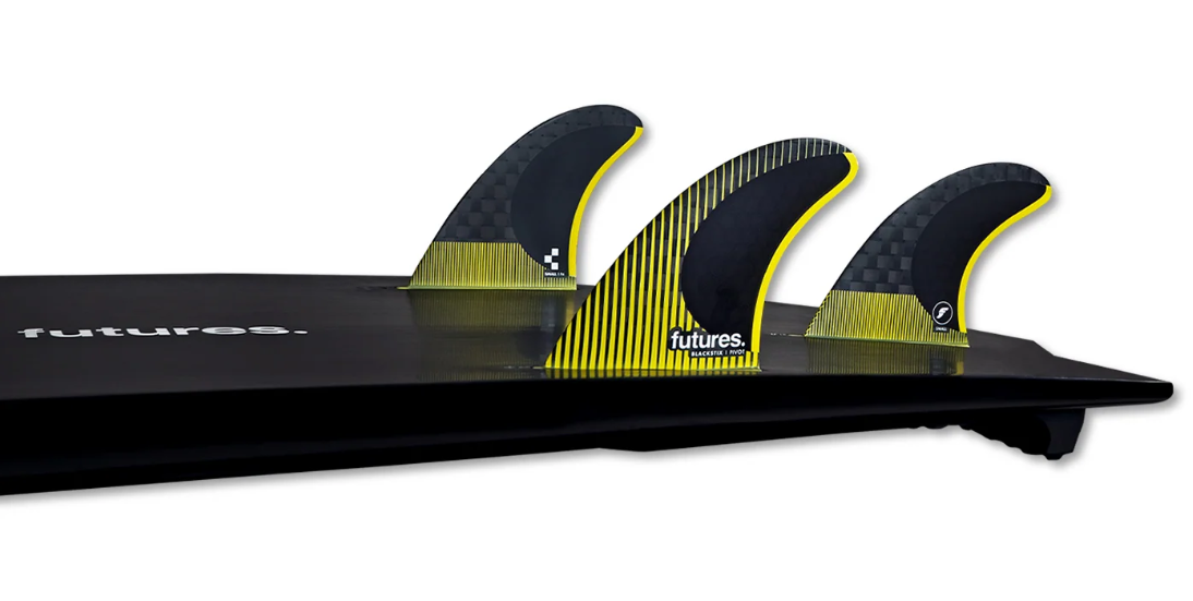 Futures Fins P4 Blackstix Thruster Surfboard Fins (small) in black and yellow in the tail of a black surfboard