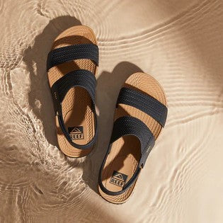 Reef Water Vista Sandals in black and tan on the sand