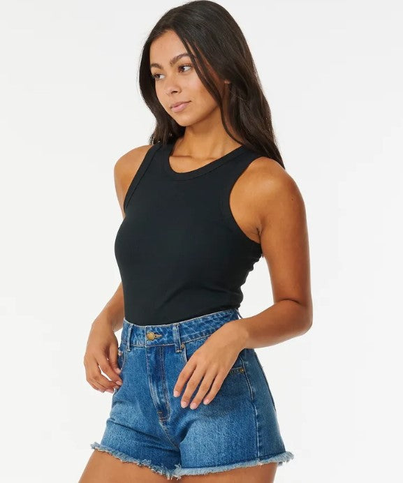 Rip Curl Classic Ribbed Tank in black on dark-haired model in denim shorts from side