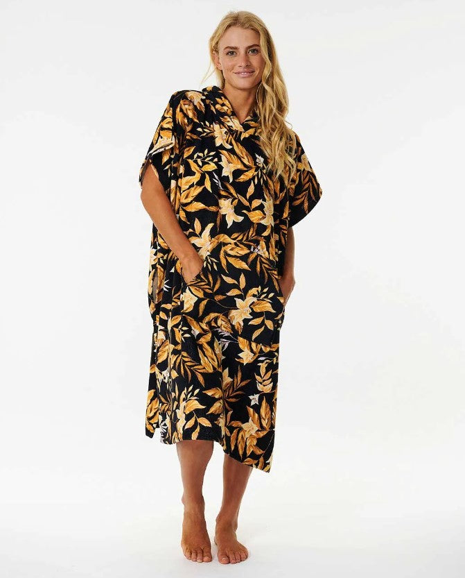 Blonde model wearing the Rip Curl womens Mixed Hooded Towel in black with palms