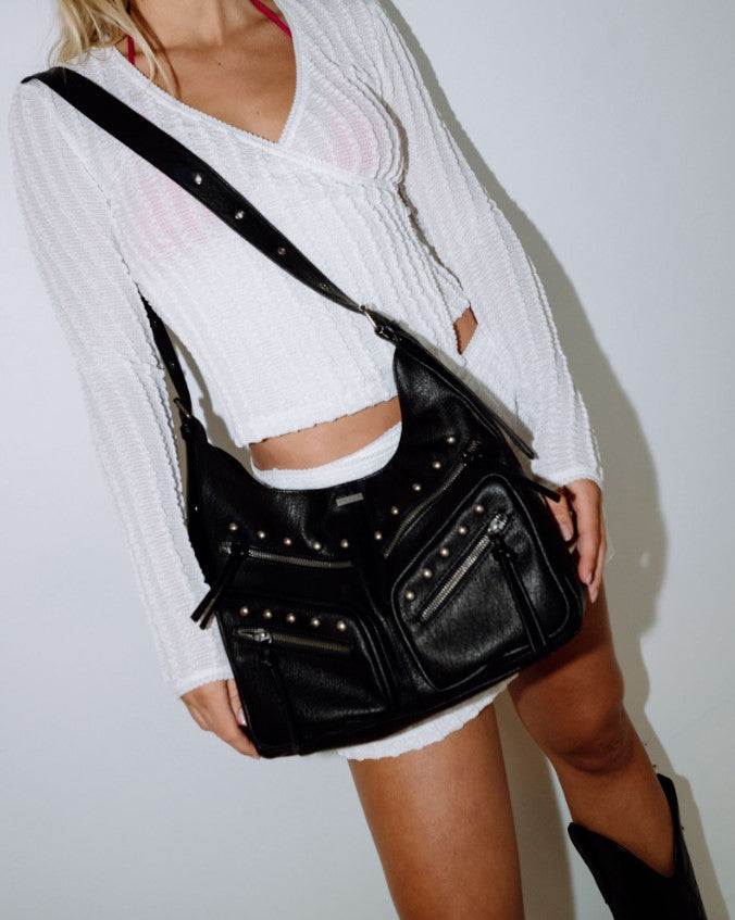 Rusty Melrose Tote Bag in black on the shoulder of a blonde woman in white clothing