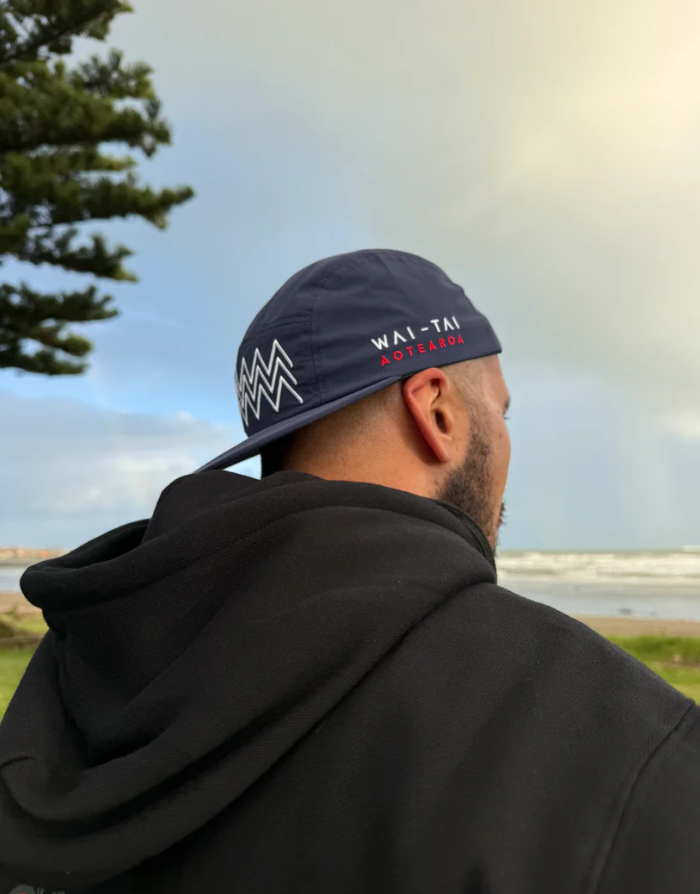 Wai-Tai Aotearoa Tohu 5 Panel Unisex Amphibian Cap in navy on male at Waikanae Beach in Gisborne from rear