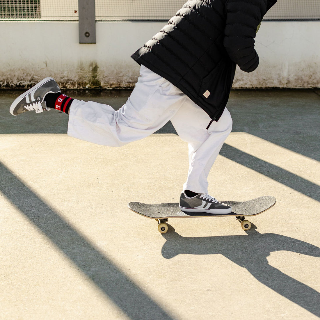 Skate wearing white jeans, Globe encore shoes and black Globe puffer jacket going for a skate