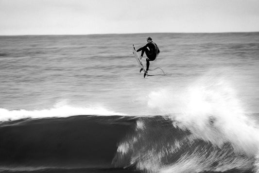 Surfer doing a huge aerial in his O'Neill Hyper X wetsuit