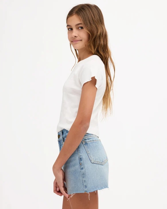 Billabong Miley Girls (8-16) Denim Short in faded indigo colourway on teen model in white Billabong tee from the side