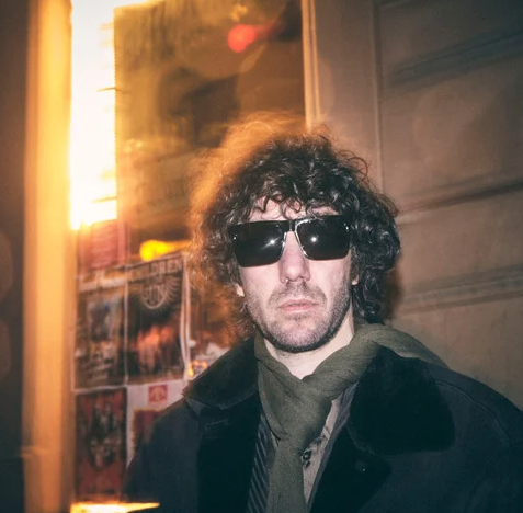 CHPO Brand Bruce Sunglasses in black on model in black jacket and olive scarf