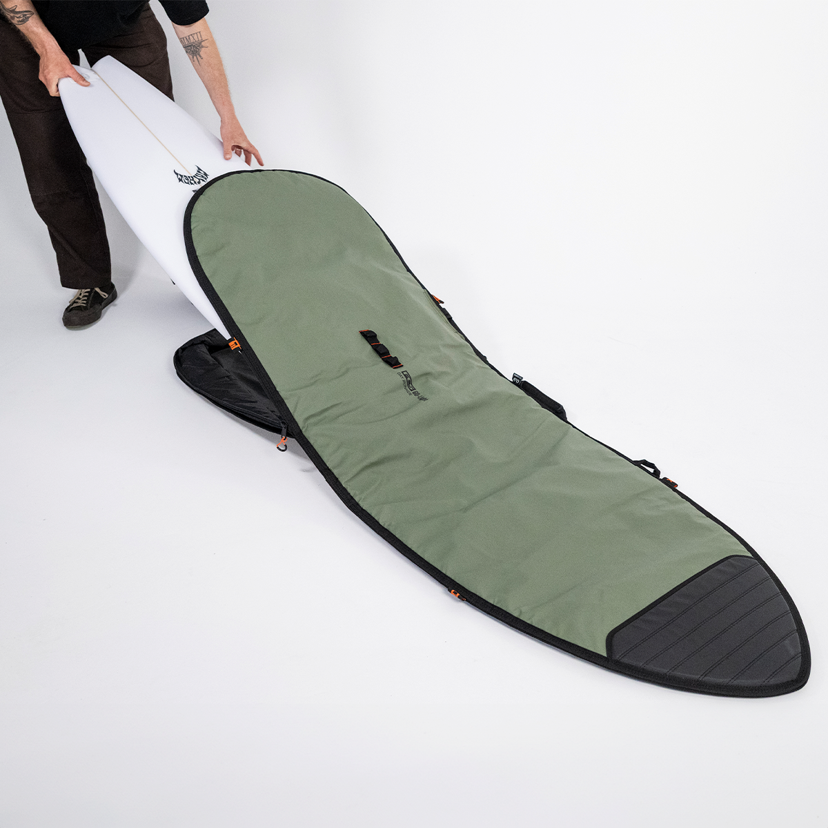 FCS 6'3 Go-Light Day Runner Shortboard Cover in alpine green with black  with board being slid in