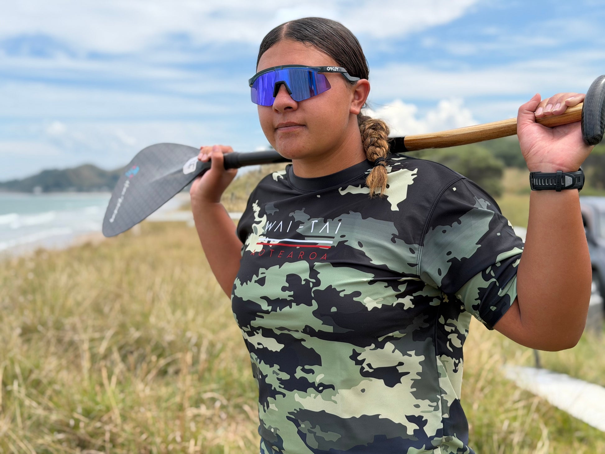 Wai-Tai Aotearoa Kaitiaki Camo Maori Design Shark Rash Tee on Hine Brooking holding a waka paddle from front