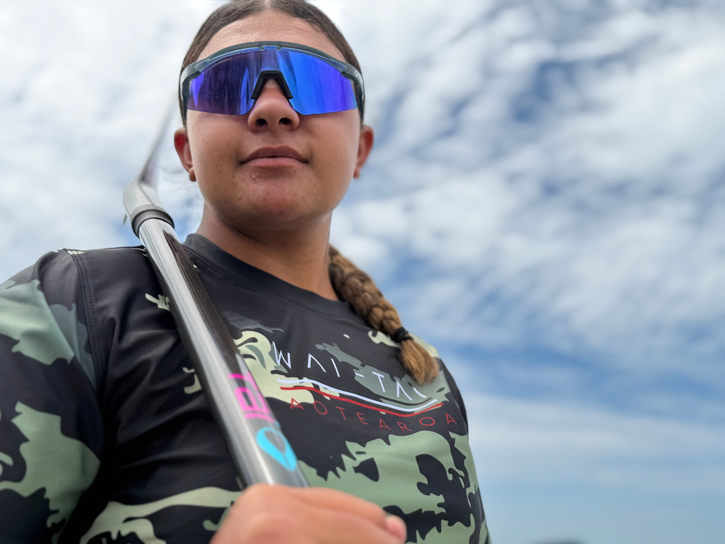 Wai-Tai Aotearoa Kaitiaki Camo Maori Design Shark Rash Tee on Hine Brooking holding a waka paddle from front close up
