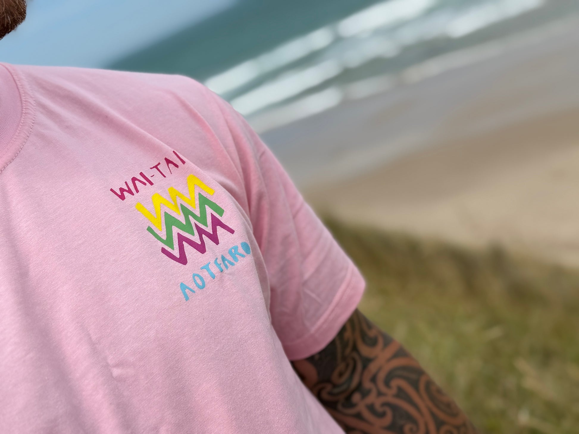 Wai-Tai Aotearoa Ono Whitu Pink Unisex Tee from front showing bright logo