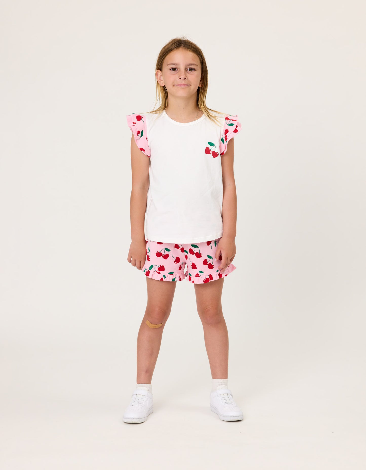 Kissed By Radicool Cherries Girls Frill Shorts  on model in white tee from front