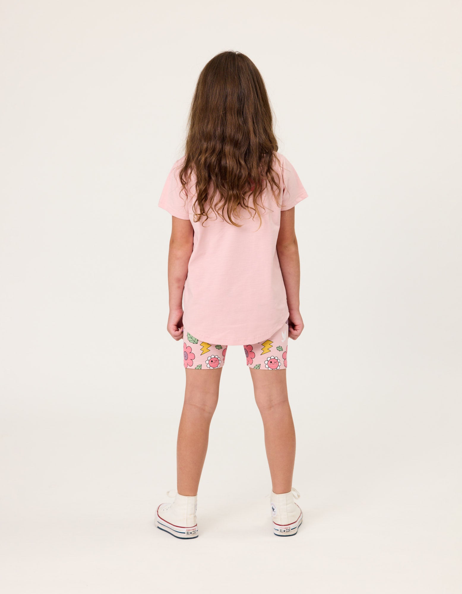 Kissed By Radicool Smiley Flowers Bike Shorts on dark-haired model wearing pink tee from rear