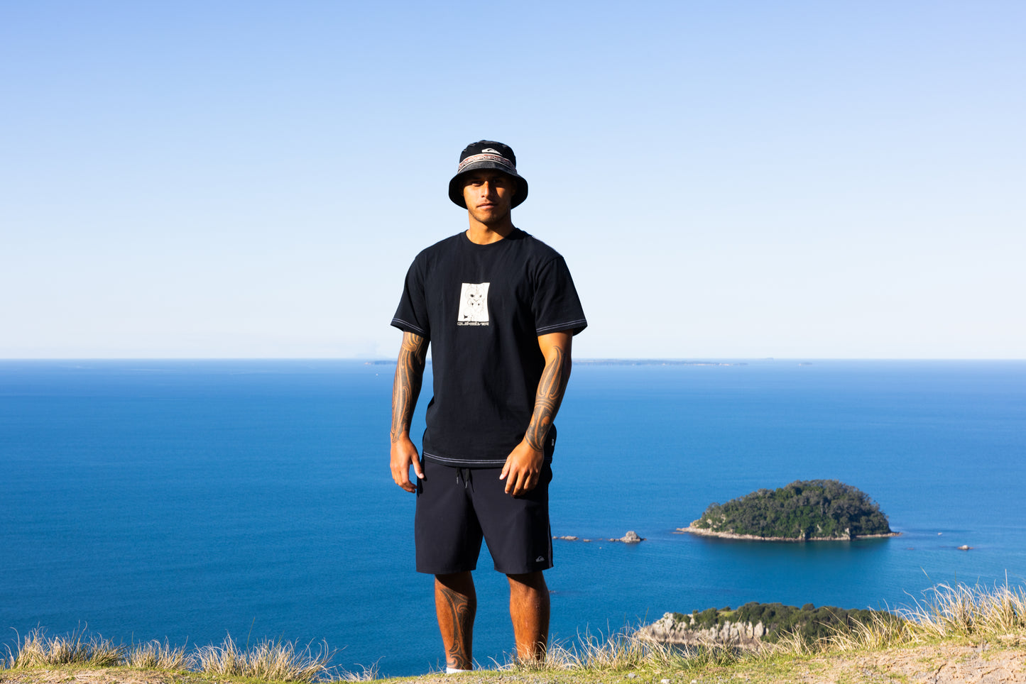 Quiksilver Marakihau Tee  in black on kehu butler overlooking island by coast