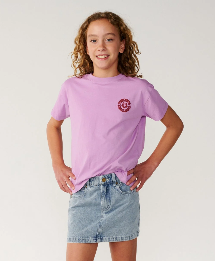 Rip Curl Surf Puff Relaxed Girls Tee
 in bright lilac colourway on young model in denim skirt from the front