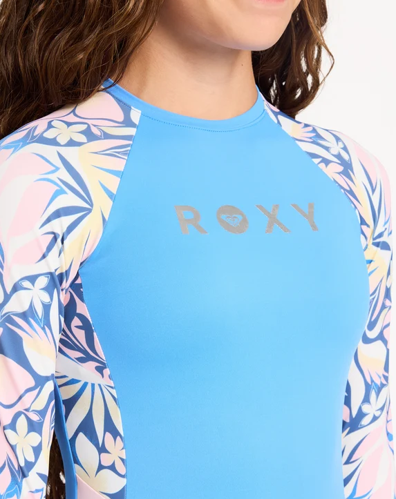 Roxy RG Active Moves LS Girls (8-16) Surfsuit in marina blue colorway on model from the front close up of Roxy logo on chest