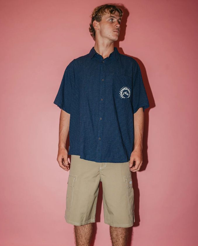 Rusty Comando Rippa 23" Men's Cargo Shorts in putty colourway on model in navy shirt from front
