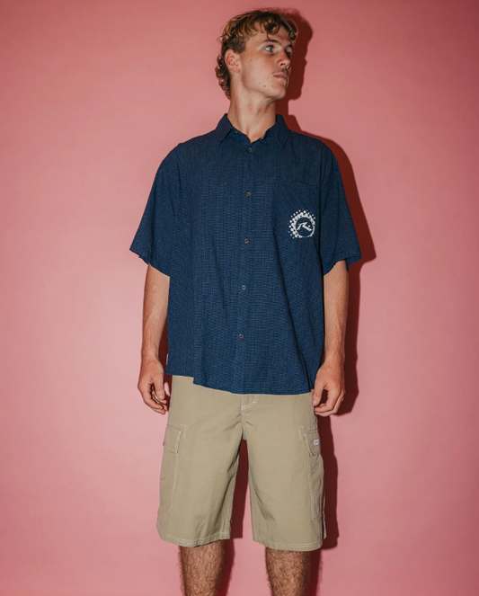 Rusty Comando Rippa 23" Men's Cargo Shorts in putty colourway on model in navy shirt from front