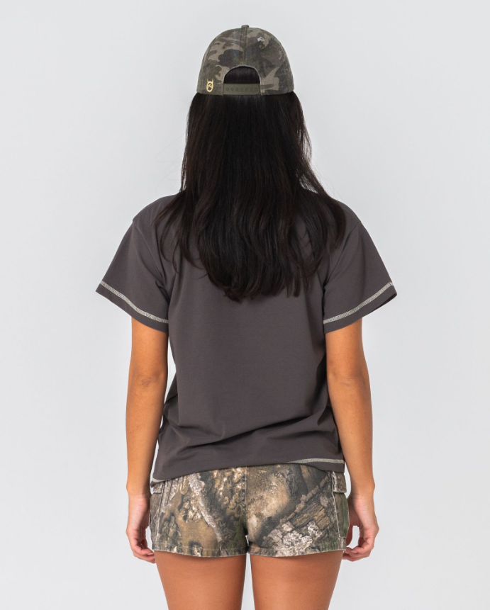 Rusty Punked Relaxed Women's T-Shirt in ultimate grey colourway on model in camo Rusty cap and shorts from the back