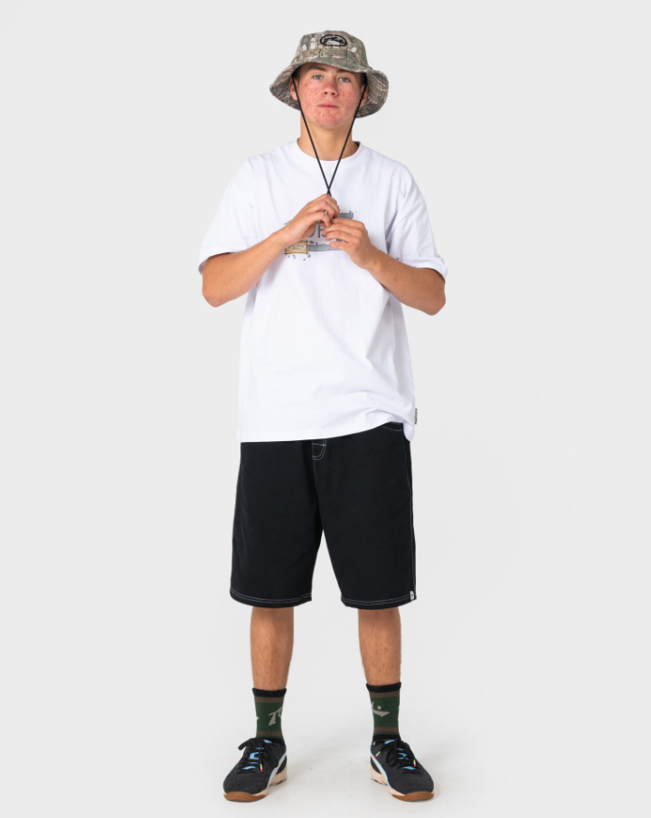 Rusty Realtree Bucket Hat in camo on model in white tee and long black shorts