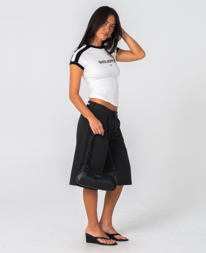 Rusty Roamie Star Fitted Baby Tee in egret white with black detailing on model from the right side
