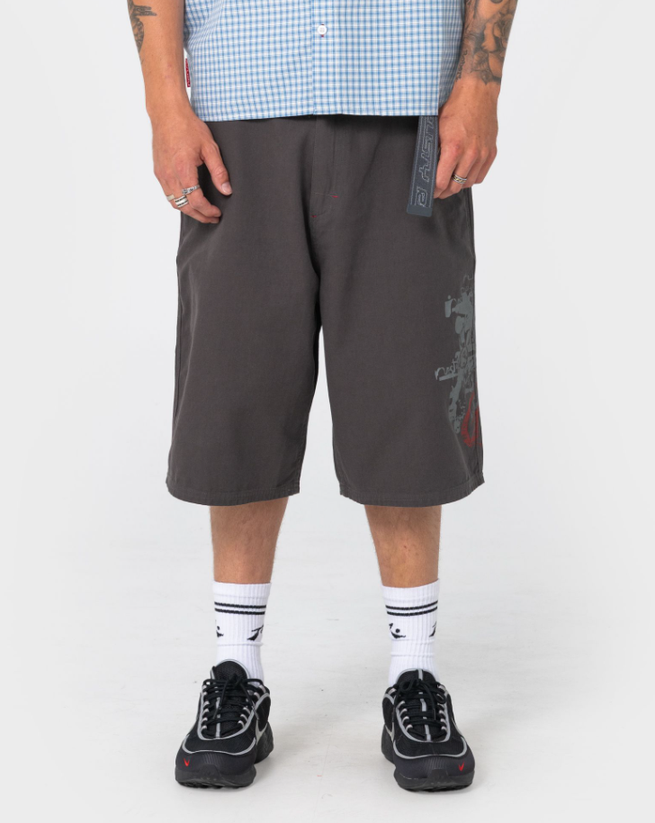 Rusty Stasher 25" Baggy Canvas Walkshorts in carbon colourway on model in blue checked shirt from close up