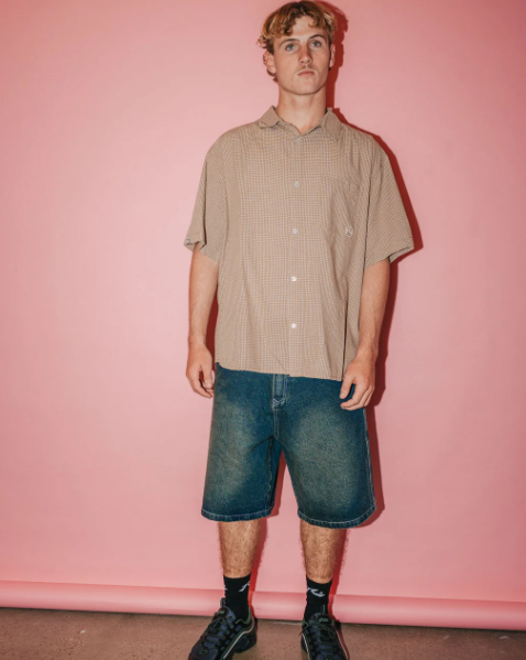 Rusty Stone Cold Baggy 24" Men's Denim Shorts in dark n dirty colourway on model in tan shirt