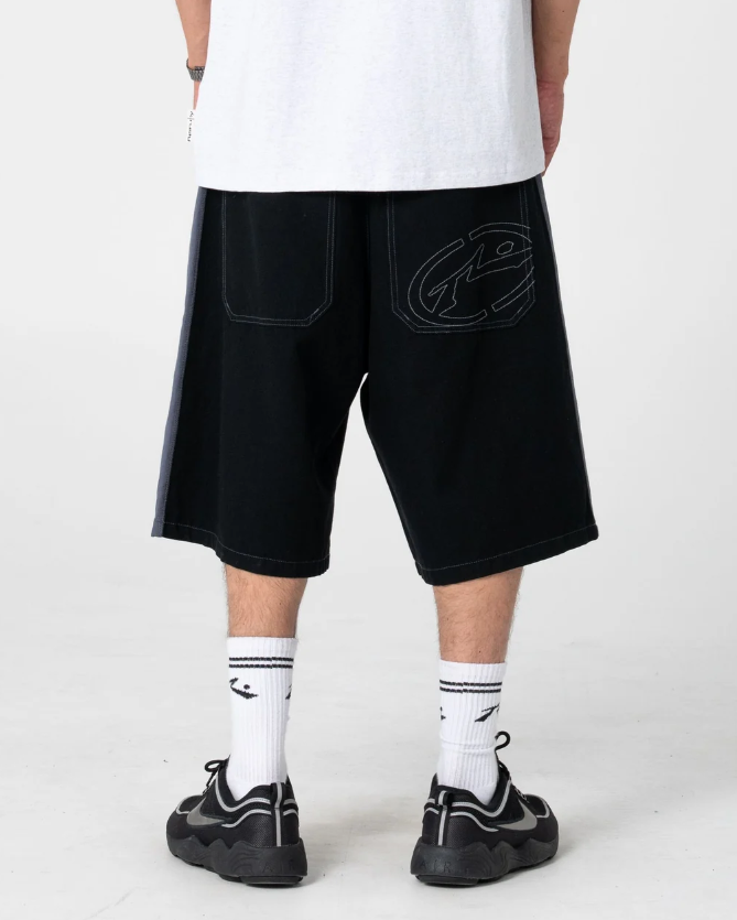 Rusty Lock 'Em 24" Cotton Canvas Shorts in black on model in white rusty tee from rear close up