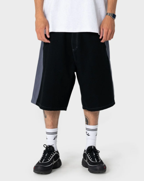 Rusty Lock 'Em 24" Cotton Canvas Shorts in black on model in white rusty tee from front close up