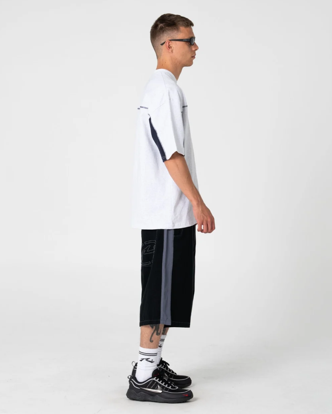 Rusty Lock 'Em 24" Cotton Canvas Shorts in black on model in white rusty tee from side