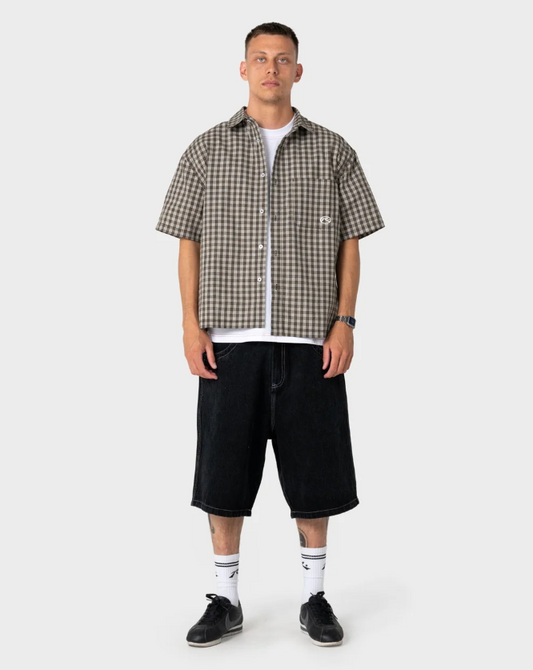 Rusty Anarchy Short Sleeve Shirt in savannah colourway on model in black denim shorts from the front