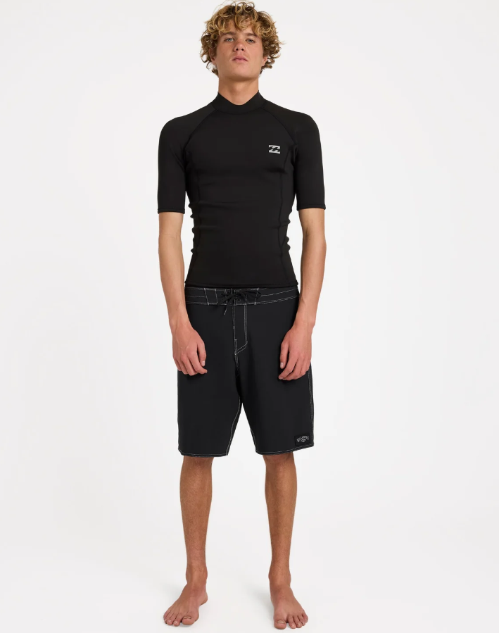 Billabong Absolute Core 1mm Short Sleeve Wetsuit Vest in black form the front on a model in black boardshorts