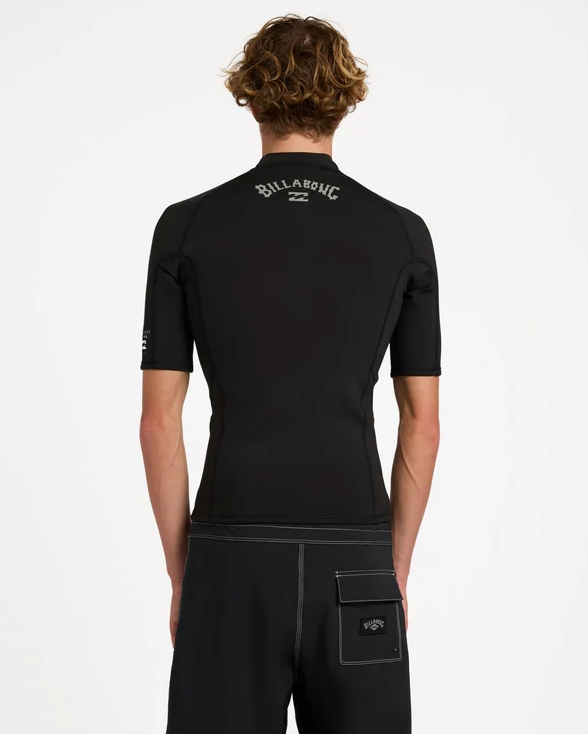 Billabong Absolute Core 1mm Short Sleeve Wetsuit Vest in black from the back on a model in black boardshorts 