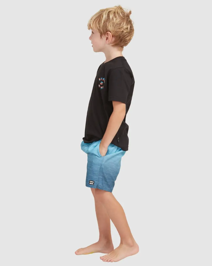 Billabong Groms Sergio Layback Shorts
 in light navy colourway on blond model in black tee from side