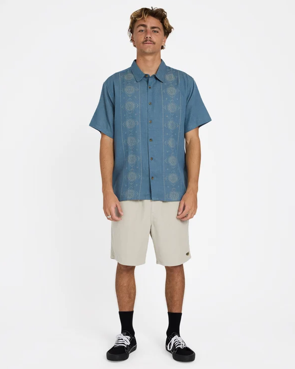 Billabong Cordoba Short Sleeve Shirt in real teal colourway from the front full length on model in beige shorts