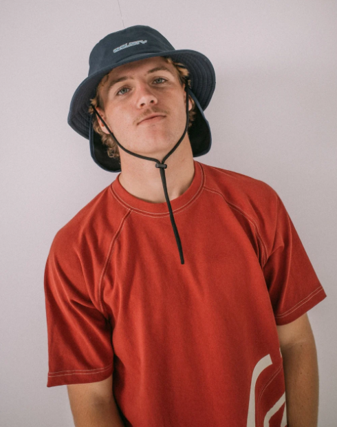 Rusty Carbon Bucket Hat in navy on model in red tee
