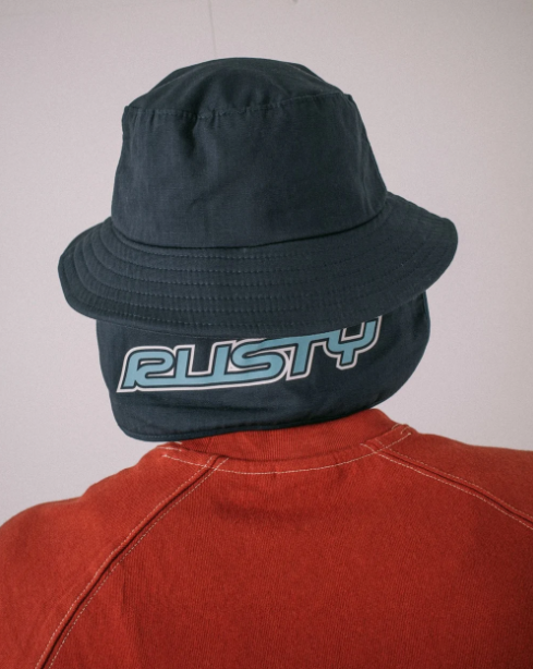 Rusty Carbon Bucket Hat in navy on model from the rear showing Rusty printed back flap