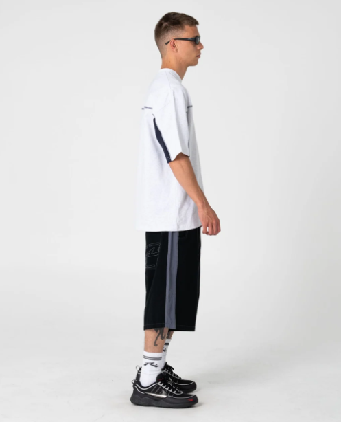 Rusty Cyber Wave Men's T-Shirt in ecru marle on model from the side in black walkshorts