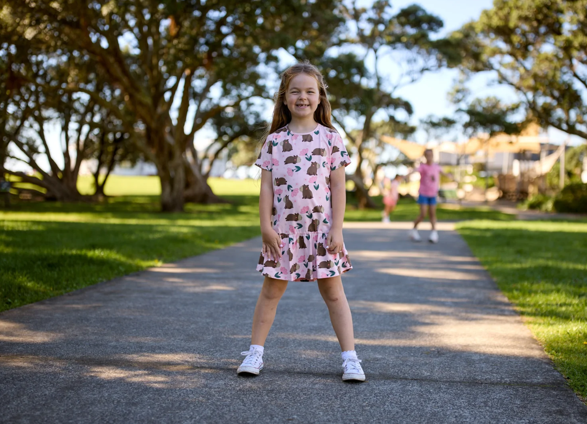 Kissed By Radicool Floral Capybaras Frill Dress in pink on girl at the park
